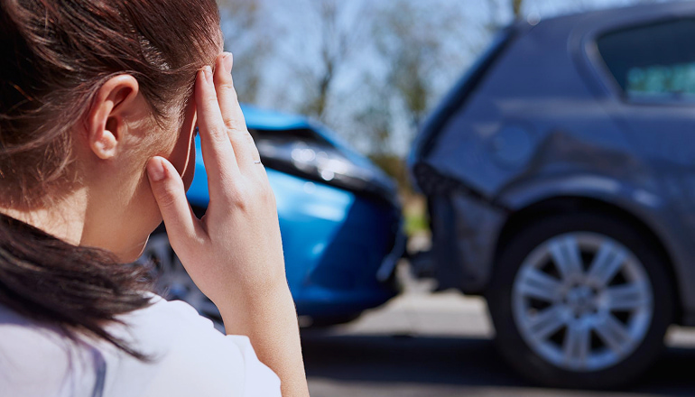 mujer con la mano en la cabeza porque no sabe que hacer tras un accidente donde no se ven lesiones